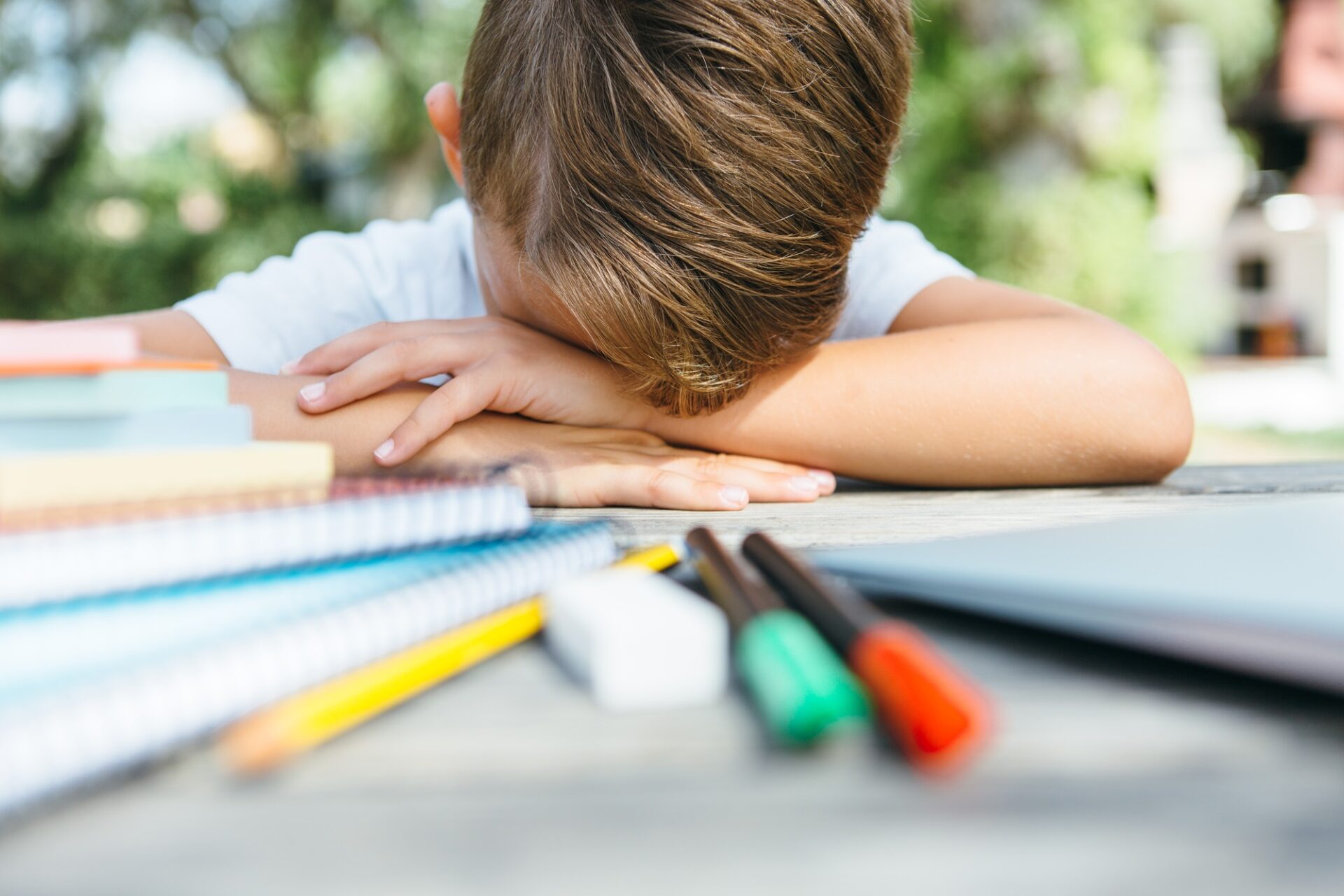Exhausted schoolboy with notebooks